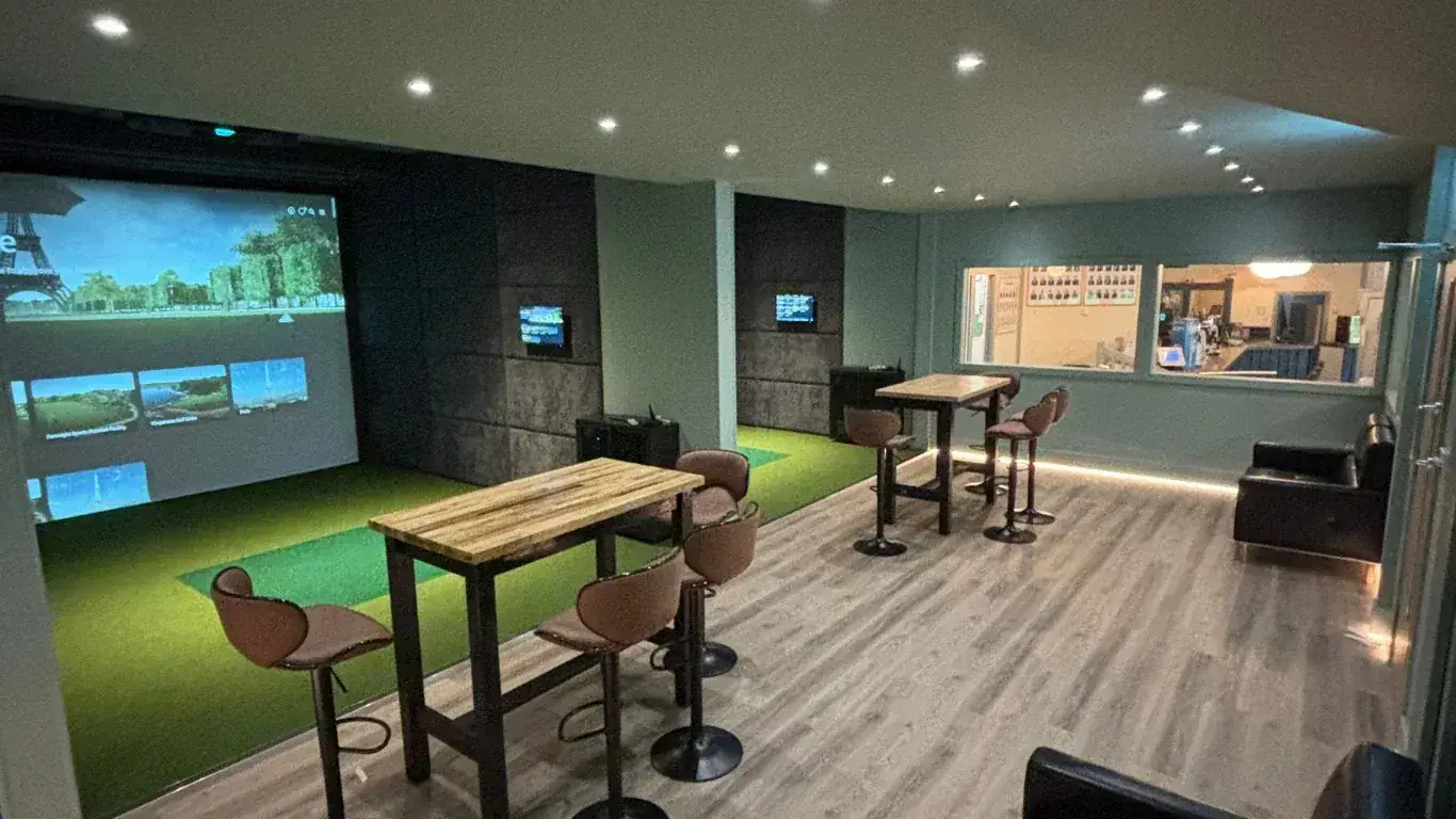 Indoor golf simulator bay with lounge seating